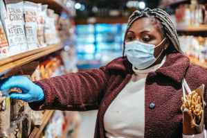 black woman choosing goods in supermarket